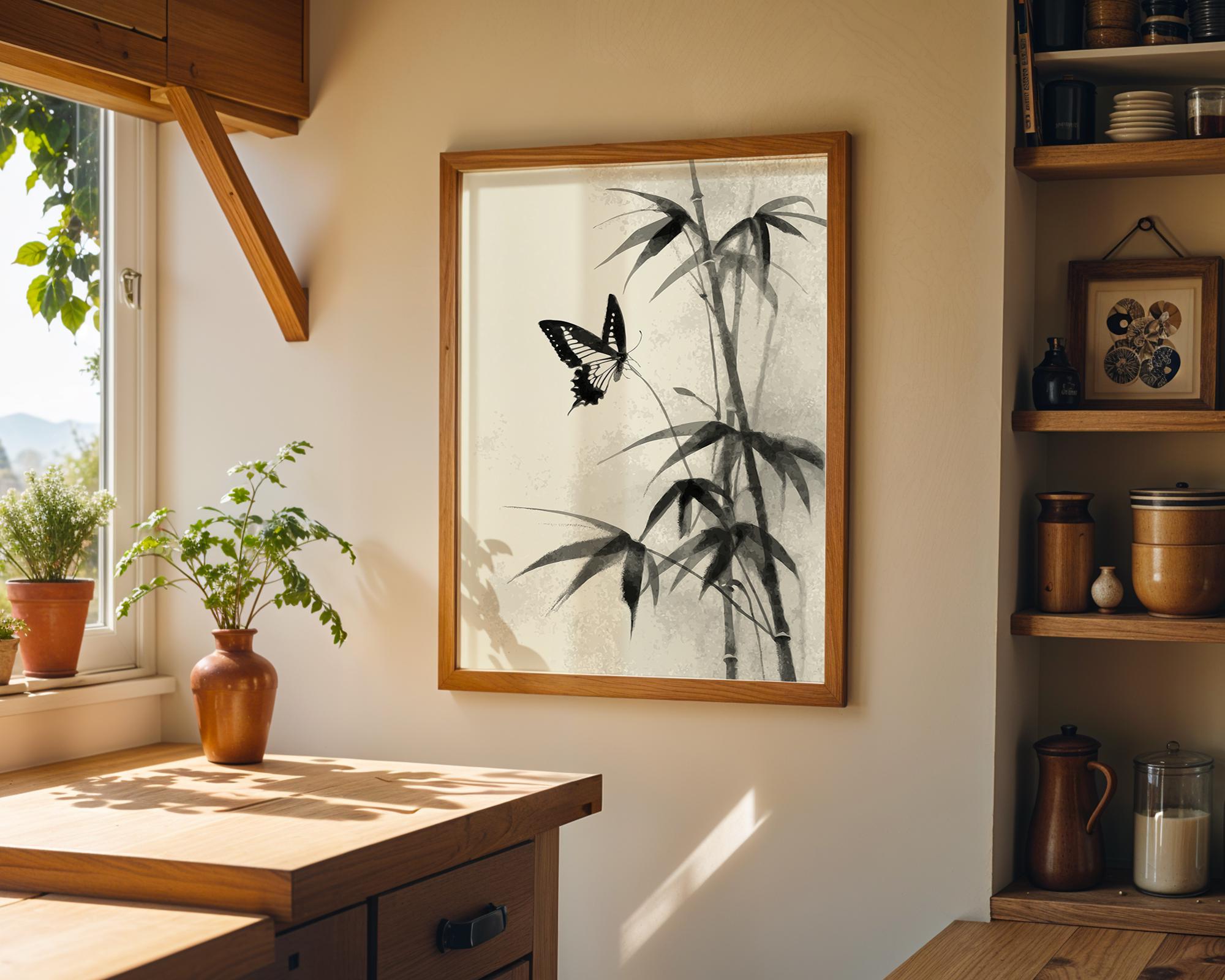 A framed wall art print featuring a black and white bamboo and butterfly design, hanging on a beige wall in a warm, sunlit kitchen or dining space with wooden cabinets, shelves, and potted plants.
