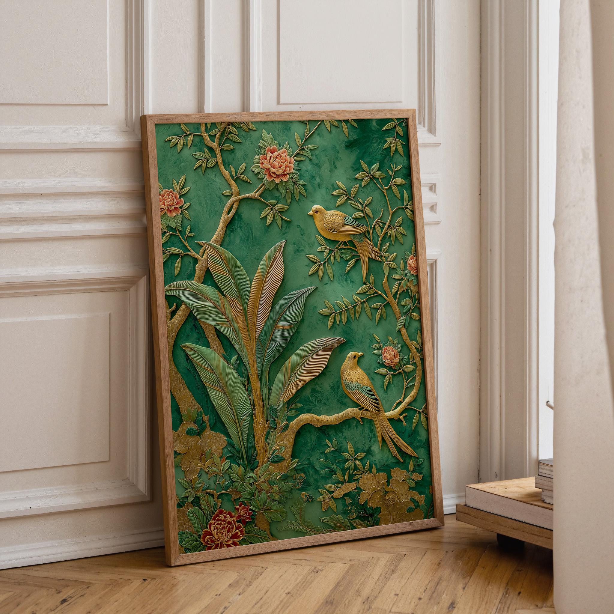 A framed decorative art print featuring a green and gold botanical scene with two yellow birds, leaning against a cream paneled wall on a light wood floor.