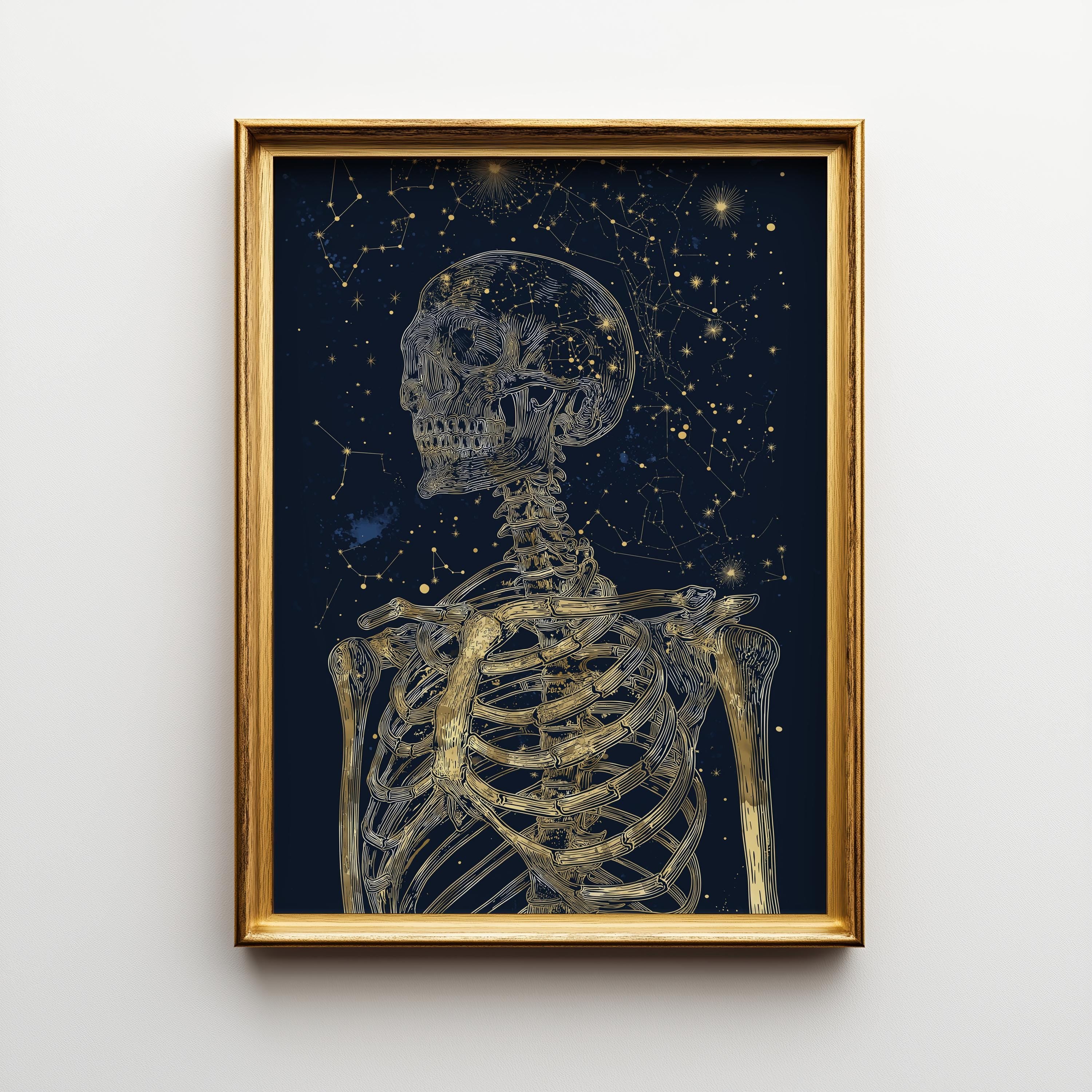 Framed wall art featuring a gold-toned skeleton against a dark starry night sky, shown hanging on a light gray wall.
